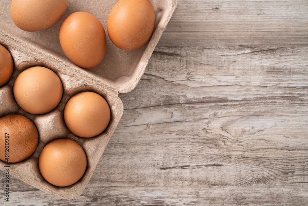 Fresh brown chicken eggs in a kraft paper egg carton. Fresh brown chicken eggs in a kraft paper egg carton.