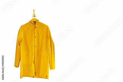 A yellow raincoat hangs on a hanger. Isolate on white background photo