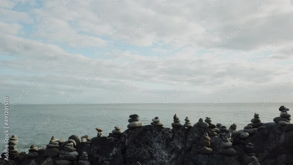 Aerial: Drone sliding besides stacks of rock cairns next to the ocean in Tropical Queensland, Australia Aerial: Drone sliding besides stacks of rock cairns next to the ocean in Tropical Queensland, Australia