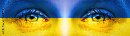 War in Ukraine background banner panorama - Close-up of child's eyes in the colors of Ukrainian flag