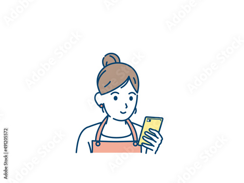 スマートフォンを使う主婦　スマホを見る女性　携帯電話　スマホ　眺める　画面を見る