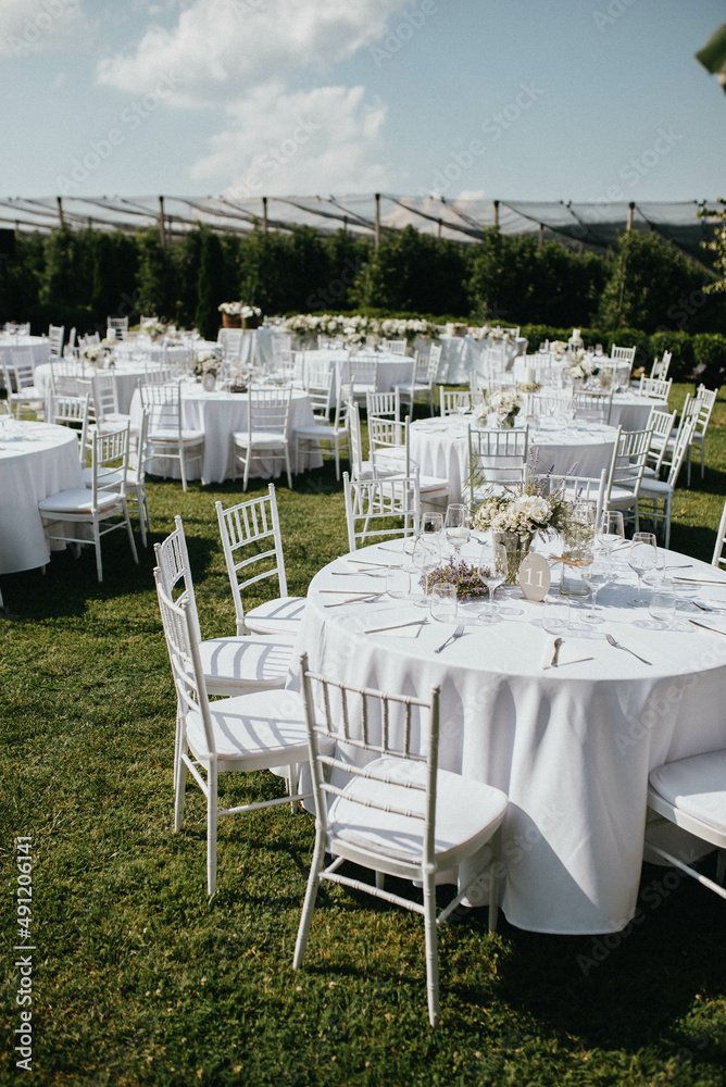 Wedding. Banquet. Chairs and honeymooners table decorated with candles. Beautiful decoration, beautiful flowers. Wedding. Banquet. Chairs and honeymooners table decorated with candles. Beautiful decoration, beautiful flowers.