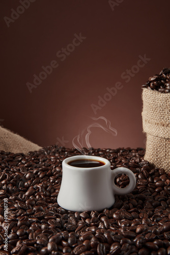 White cup with coffee beans on dark background