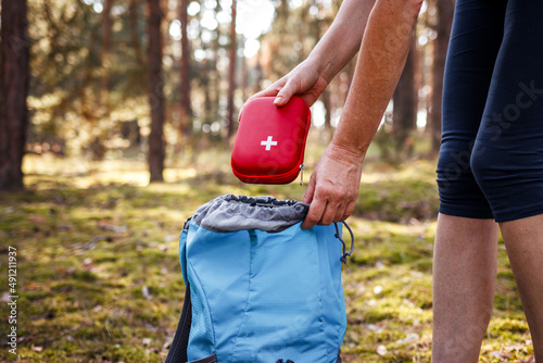 Obraz na płótnie Woman taking out first aid kit from backpack