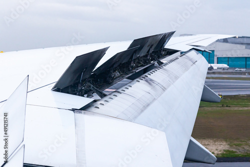 The wing of an aircraft with open flaps on the wing that is landing. photo