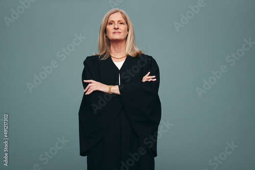Mature judge standing with her arms crossed in a studio photo