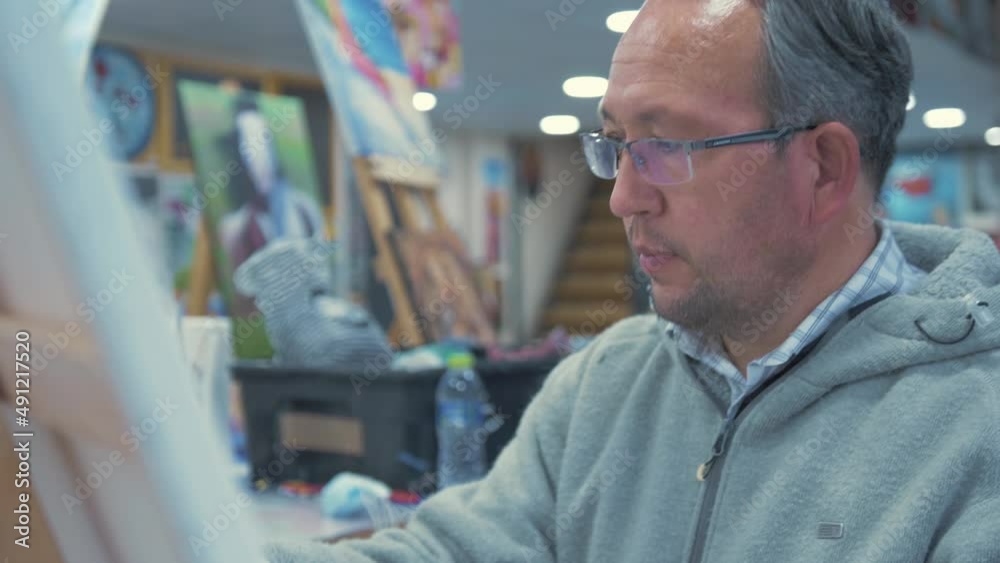 Professional artist in gallery marking blank canvas with chalk