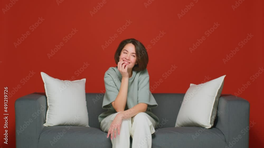A cunning girl is plotting an insidious plan. Thinks through the details. Makes a choice. An emotional woman on a red background. A cunning girl is plotting an insidious plan. Thinks through the details. Makes a choice. An emotional woman on a red background.
