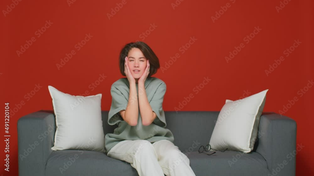 A girl with poor eyesight squints to see the TV screen. Then he puts on his glasses to see well. The concept of myopia. A girl with poor eyesight squints to see the TV screen. Then he puts on his glasses to see well. The concept of myopia.