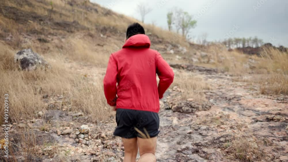 Smart trail runner man running on rocky mountain. Athlete jog, exercising outdoor for healthy. Confident and powerful marathon man running workout and cardio. Sport and Lifestyle concept. Smart trail runner man running on rocky mountain. Athlete jog, exercising outdoor for healthy. Confident and powerful marathon man running workout and cardio. Sport and Lifestyle concept.