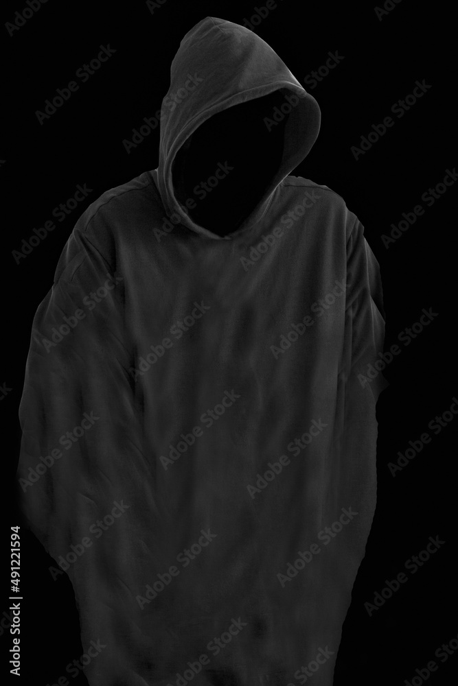 Faceless person in hoodie in the darkness. Silhouette of reaper the death on black background. Hooded criminal in dark. Mystery man with hood. Hooligan in hoodie. Crime and violence concept. Faceless person in hoodie in the darkness. Silhouette of reaper the death on black background. Hooded criminal in dark. Mystery man with hood. Hooligan in hoodie. Crime and violence concept.