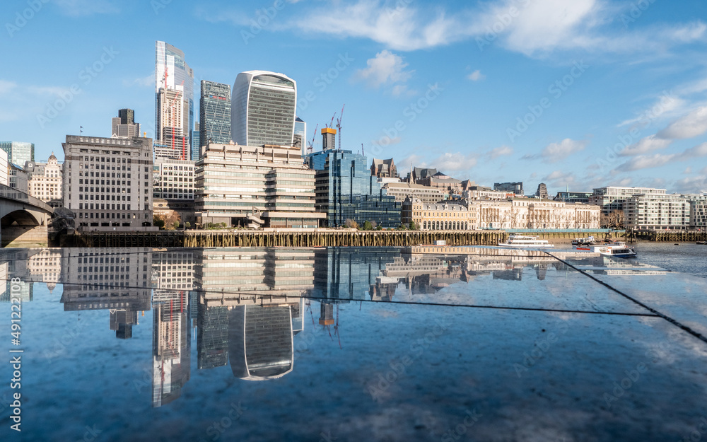 London reflections. The skyscrapers and modern architecture of the City of London business and financial district mirrored on smooth polished marble.