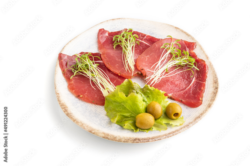 Slices of smoked salted meat with cilantro microgreen isolated on white. Side view, close up.