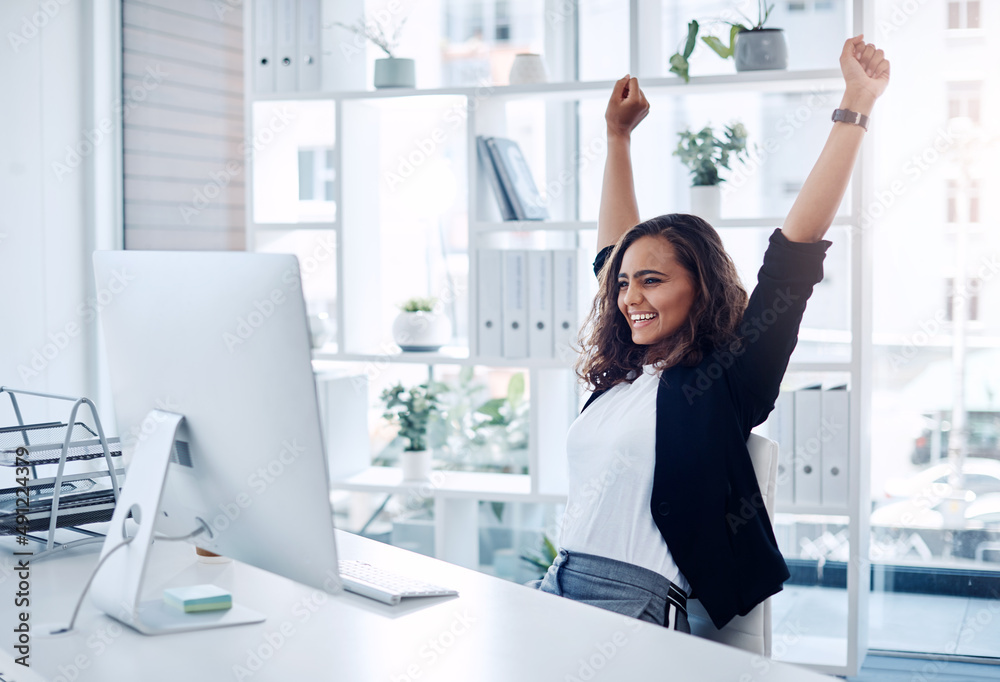 Success is all mine. Shot of a young businesswoman cheering while working in an office. Success is all mine. Shot of a young businesswoman cheering while working in an office.