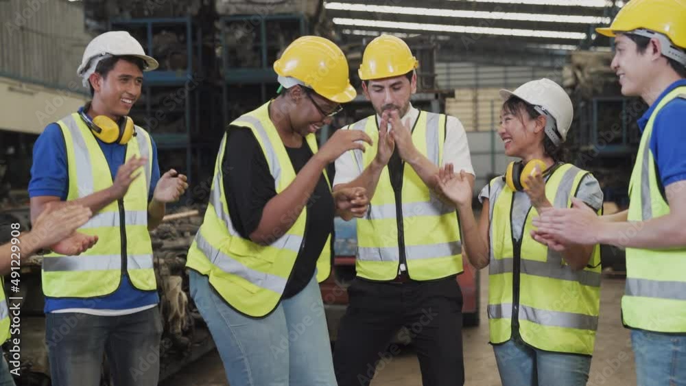 happy young factory worker with colleagues. Group of happy workers in uniform at factory. Dance.