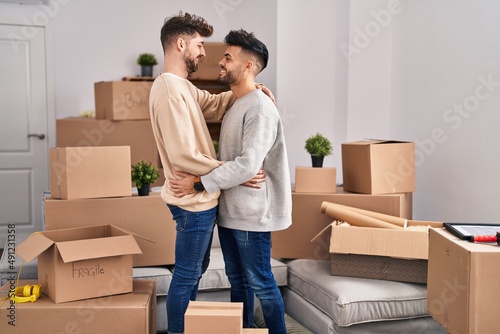 Young couple hugging each other standing at new home