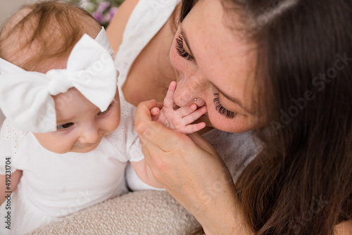 brunette mom kisses the child's hand. Tender photo of mom and daughter