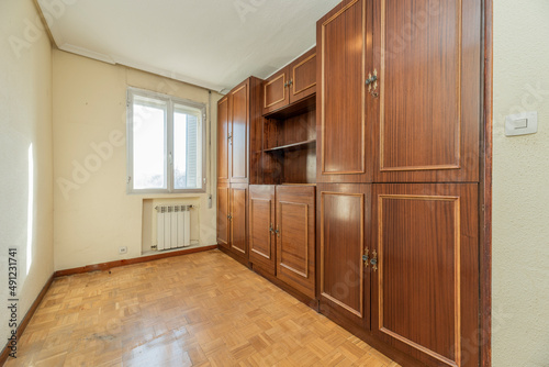 living room with a wall full of dark wood built-ins and oak parquet flooring