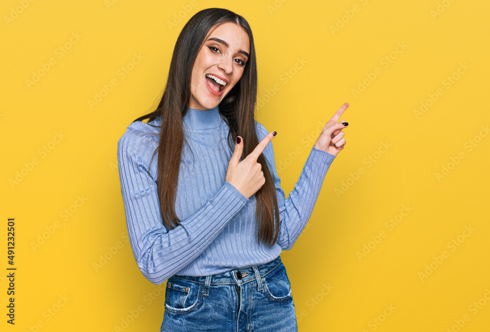 Young beautiful woman wearing casual winter sweater smiling and looking at the camera pointing with two hands and fingers to the side. Young beautiful woman wearing casual winter sweater smiling and looking at the camera pointing with two hands and fingers to the side.