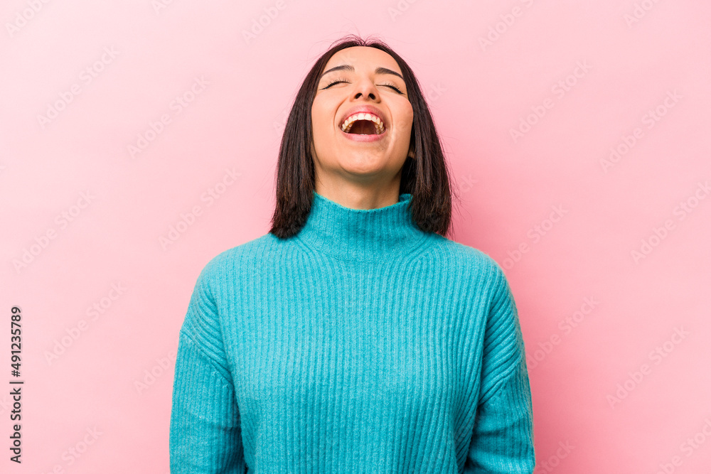 Young hispanic woman isolated on pink background relaxed and happy laughing, neck stretched showing teeth. Young hispanic woman isolated on pink background relaxed and happy laughing, neck stretched showing teeth.