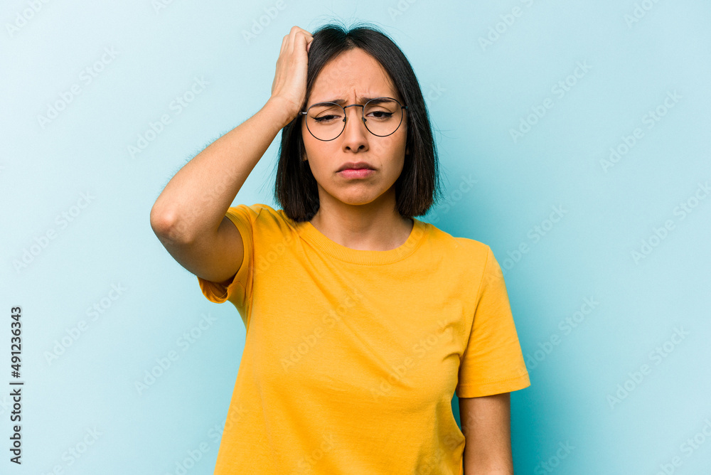 Young hispanic woman isolated on blue background tired and very sleepy keeping hand on head. Young hispanic woman isolated on blue background tired and very sleepy keeping hand on head.