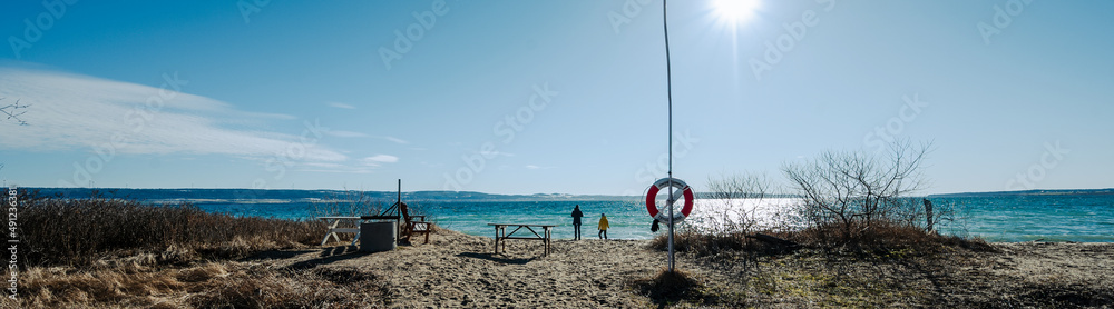 Kinder spielen am Strand mit Sonne und blauen HImmel