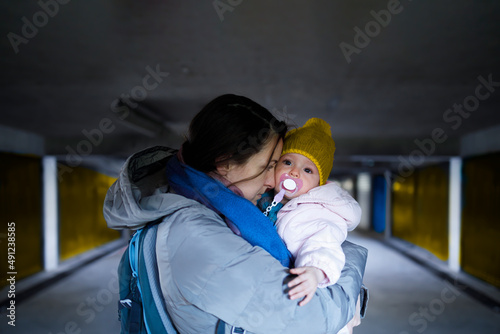 A mother holding her frightened child in the bomb shelter