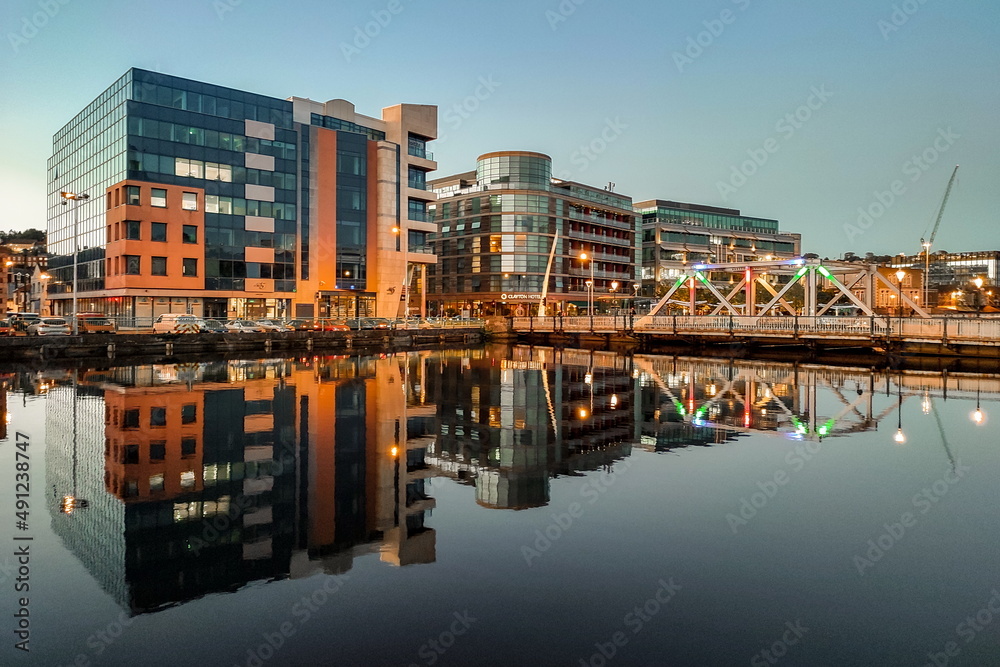 Fototapeta premium Sunset in Cork City Ireland business and classic buildings with reflection on the river