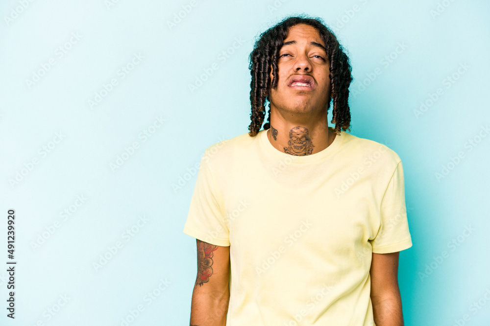 Young African American man isolated on blue background shouting very angry, rage concept, frustrated. Young African American man isolated on blue background shouting very angry, rage concept, frustrated.