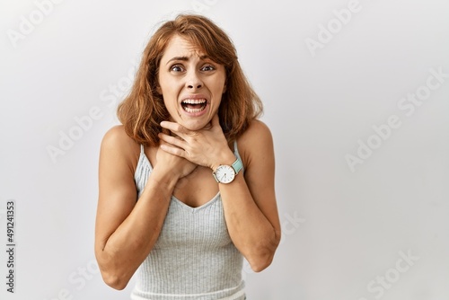 Beautiful caucasian woman standing over isolated background shouting suffocate because painful strangle. health problem. asphyxiate and suicide concept.