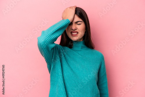 Young caucasian woman isolated on pink background forgetting something, slapping forehead with palm and closing eyes. © Asier