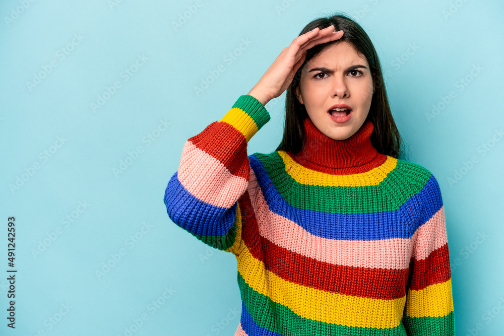 Young caucasian woman isolated on blue background shouts loud, keeps eyes opened and hands tense. Young caucasian woman isolated on blue background shouts loud, keeps eyes opened and hands tense.