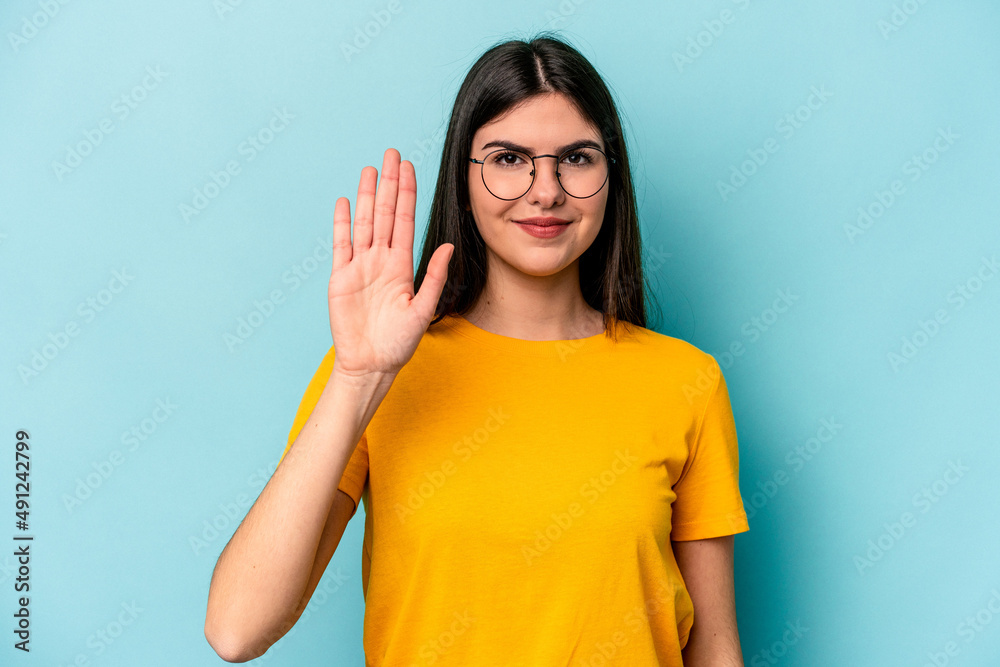 Young caucasian woman isolated on blue background smiling cheerful showing number five with fingers. Young caucasian woman isolated on blue background smiling cheerful showing number five with fingers.