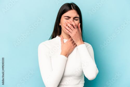 Young caucasian woman isolated on blue background suffers pain in throat due a virus or infection. © Asier