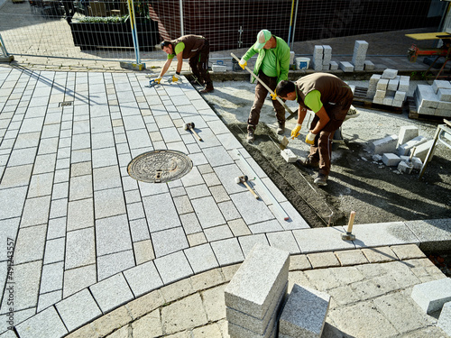 Pavers working on footpath to install paving stones photo