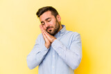 Young caucasian man isolated on yellow background yawning showing a tired gesture covering mouth with hand.