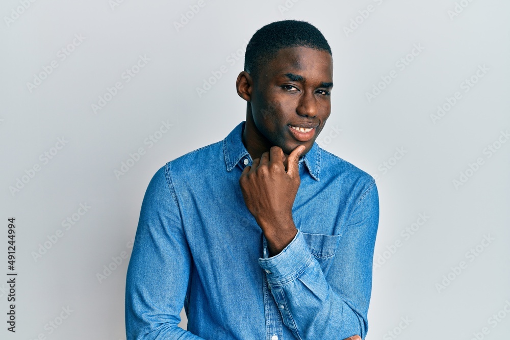 Young african american man wearing casual clothes smiling looking confident at the camera with crossed arms and hand on chin. thinking positive. Young african american man wearing casual clothes smiling looking confident at the camera with crossed arms and hand on chin. thinking positive.