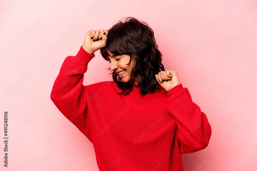 Young hispanic woman isolated on pink background celebrating a special day, jumps and raise arms with energy. Young hispanic woman isolated on pink background celebrating a special day, jumps and raise arms with energy.
