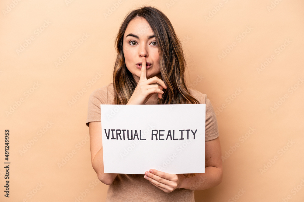Young caucasian woman holding a virtual reality placard isolated on beige background keeping a secret or asking for silence. Young caucasian woman holding a virtual reality placard isolated on beige background keeping a secret or asking for silence.