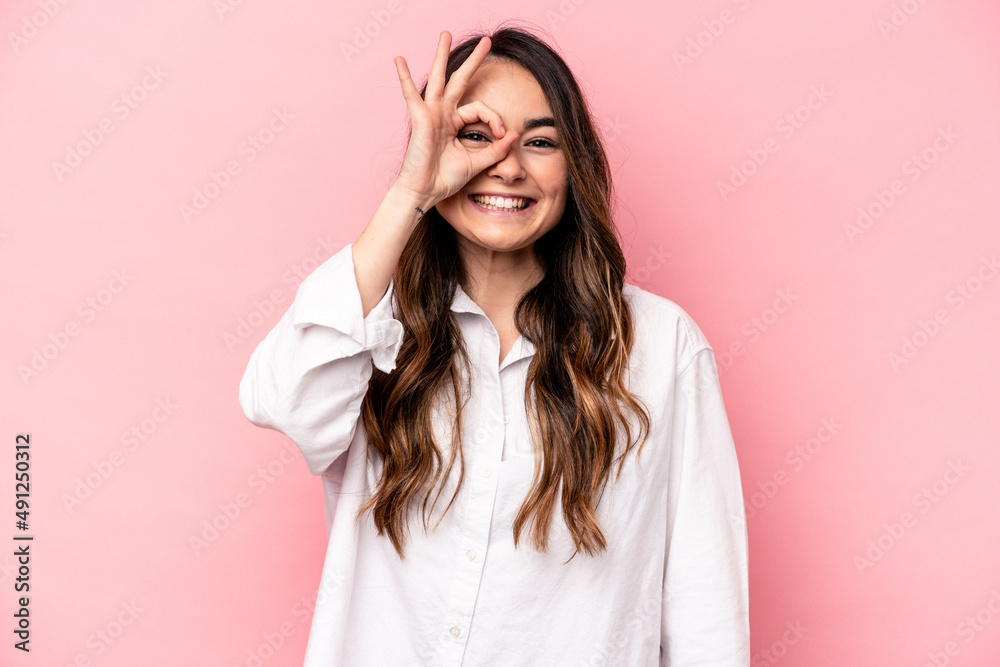 Young caucasian woman isolated on pink background excited keeping ok gesture on eye.
