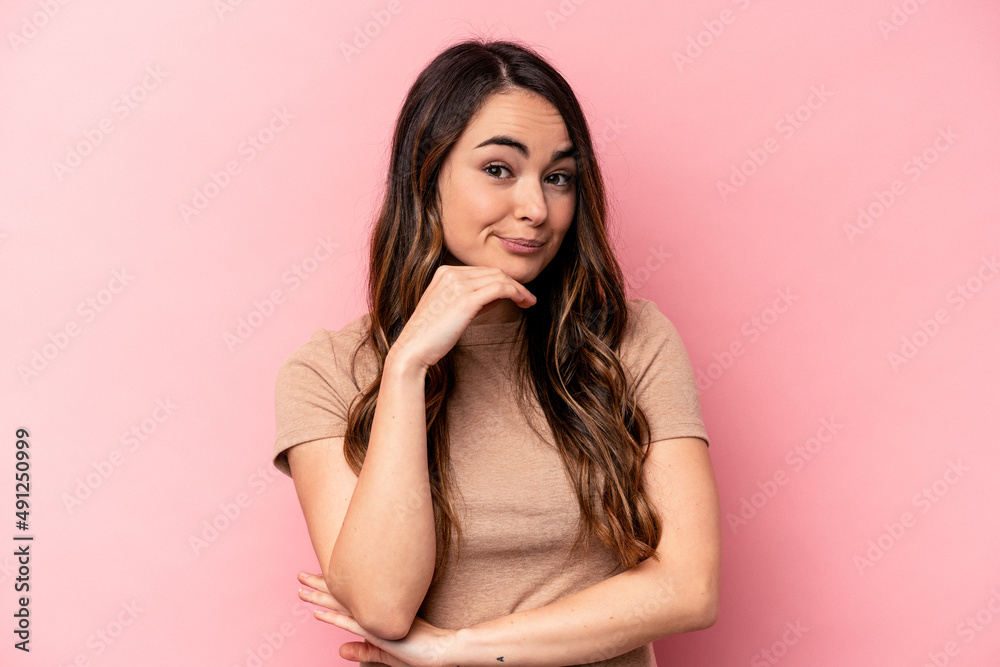 Young caucasian woman isolated on pink background thinking and looking up, being reflective, contemplating, having a fantasy.