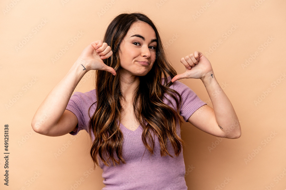 Young caucasian woman isolated on beige background feels proud and self confident, example to follow. Young caucasian woman isolated on beige background feels proud and self confident, example to follow.