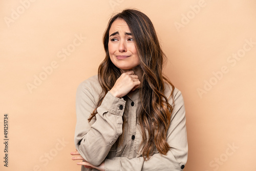 Young caucasian woman isolated on beige background suffers pain in throat due a virus or infection.
