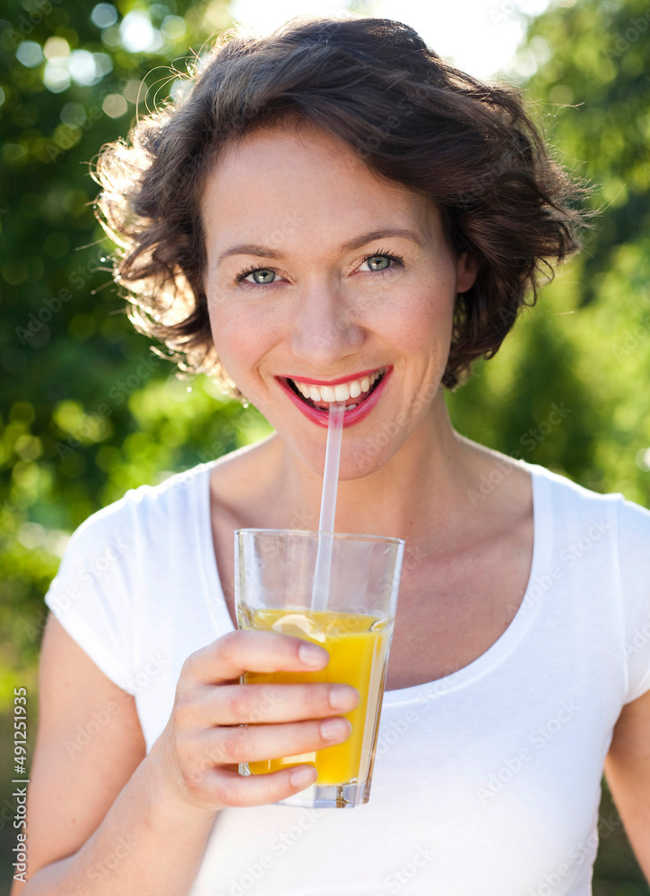 Happy woman drinking orange juice on sunny day Happy woman drinking orange juice on sunny day
