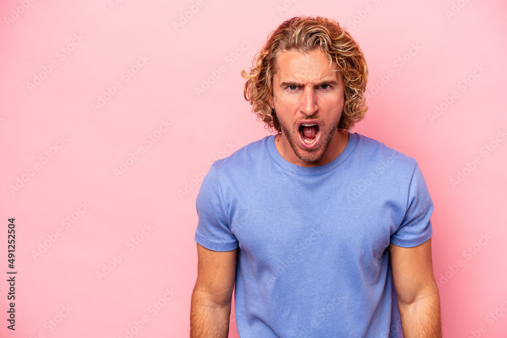 Young caucasian man isolated on pink background shouting very angry, rage concept, frustrated. Young caucasian man isolated on pink background shouting very angry, rage concept, frustrated.