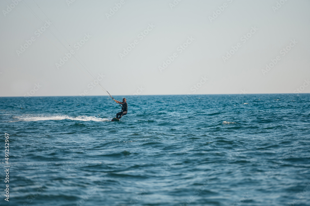 Woman kitesurfing on the ocean waters Woman kitesurfing on the ocean waters