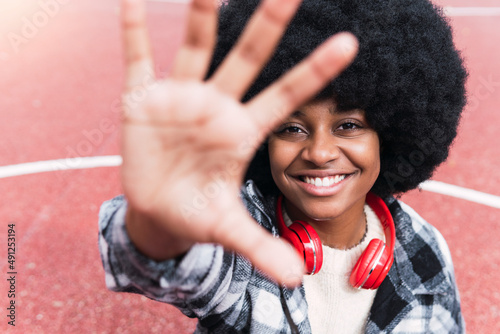 Happy afro woman gesturing on sports court photo