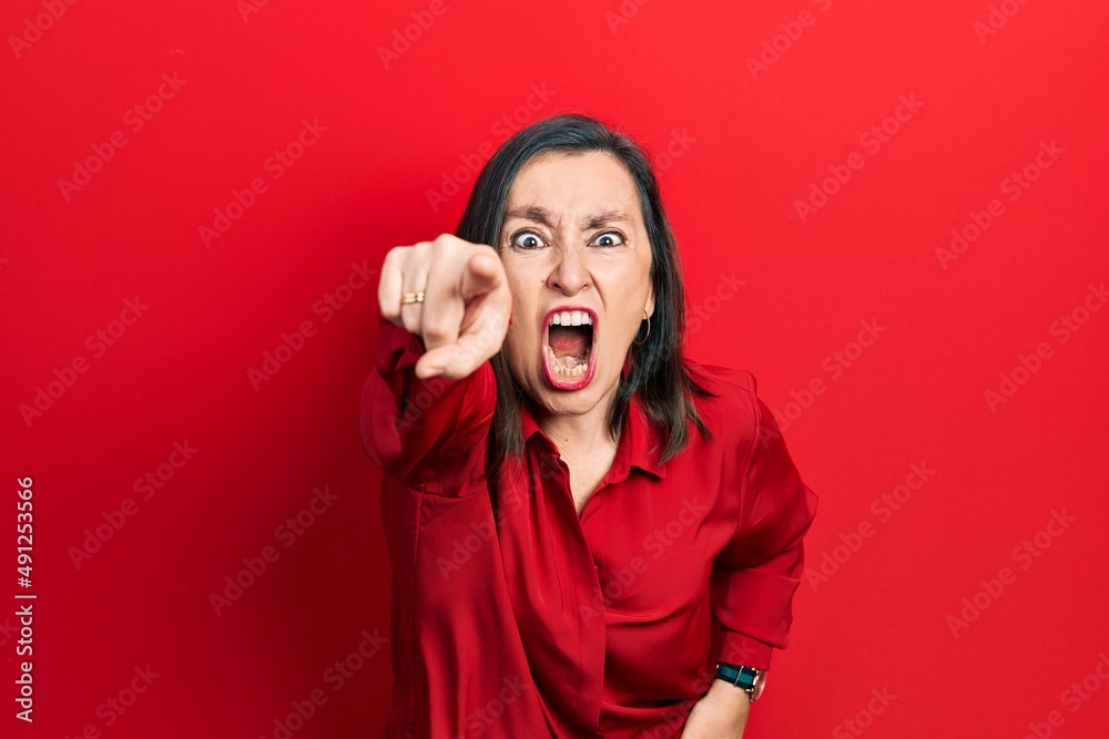 Middle age hispanic woman wearing casual clothes pointing displeased and frustrated to the camera, angry and furious with you Middle age hispanic woman wearing casual clothes pointing displeased and frustrated to the camera, angry and furious with you