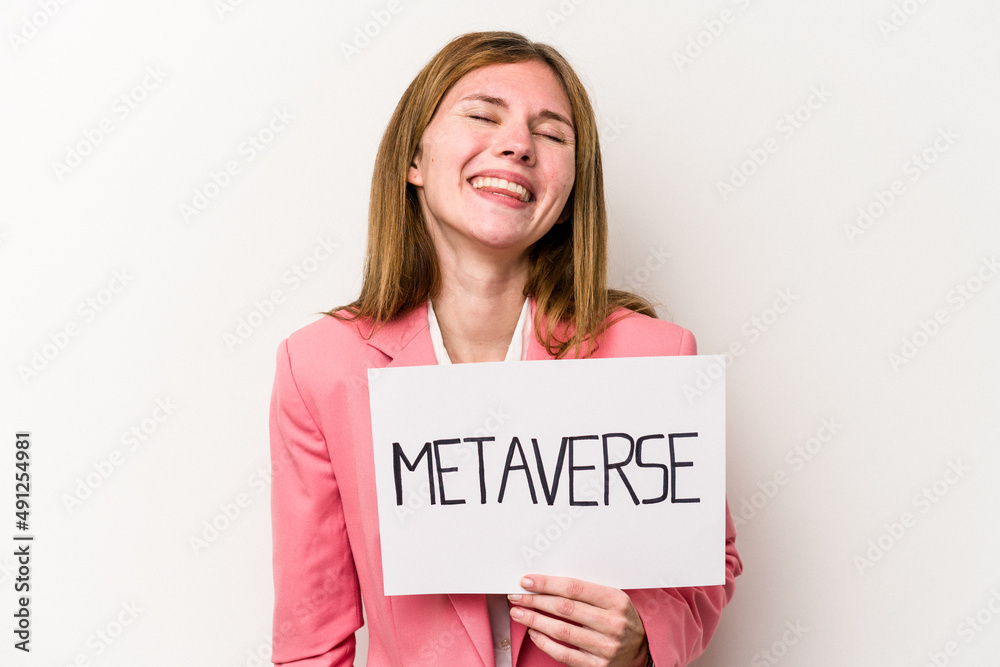Young English business woman holding a metaverse placard isolated on white background laughing and having fun. Young English business woman holding a metaverse placard isolated on white background laughing and having fun.