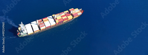 Aerial drone ultra wide top down photo of anchored container ship in loading - unloading in logistics terminal port